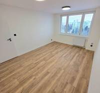 A place in a 3-room apartment with a wooden decor floor and ceiling lights.