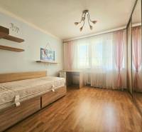 Children's room in a 3-room apartment with a bed, cabinets, and a wooden decor floor.