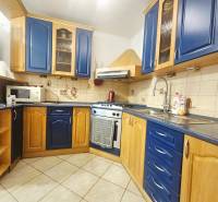 A kitchen in a 3-room apartment with ceramic tiles and blue cabinets.