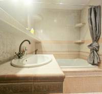 Bathroom in a 3-room apartment with a bathtub, sink, and tiles in neutral shades.