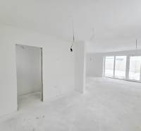 A spacious interior of a family house with white walls and large windows.