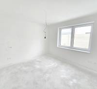 A white room with a window in a family house, ready for final touches and furnishing.