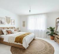Bedroom in a family house with a bed, drawings, a plant, and natural decorations.