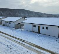A snow-covered street Pod Stráňou in Sokolovce with new bungalows in a row development.