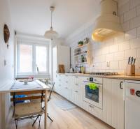 A kitchen with a wood-patterned floor and a dining table in a two-room apartment.