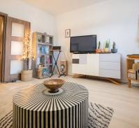 Living room in a two-room apartment with a wooden decor floor, stylish furniture, and decorations.