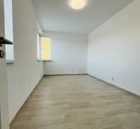 An empty room with a wooden decor floor in a 3-room apartment.