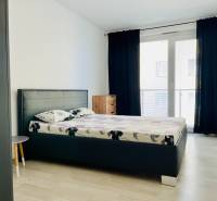 Bedroom in a 3-room apartment with a bed, nightstands, and a floor with a wooden decor.