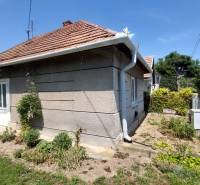 A family house in Nevidzany with a landscaped garden, fencing, and a sloped roof.