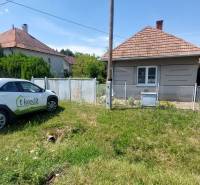 A family house in Nevidzany with a car in front of the house and greenery in the background.