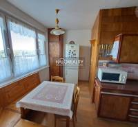 Living room in a three-room apartment with a wooden decor floor, a sofa set, and wall decorations.