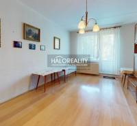 A kitchen in a 3-room apartment with the original cabinetry and flooring with a wood design.