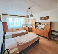 A bedroom in a 3-room apartment with two beds and a wooden decor floor.