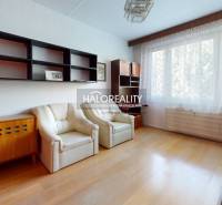 A kitchen in a 3-room apartment with a wood-patterned floor and window seating.