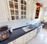 A kitchen in a 3-room apartment with white cabinets and appliances, no Topoľčany.