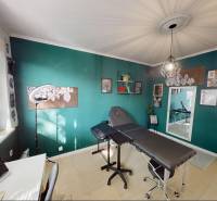 A room in a 3-room apartment with a turquoise wall, an armchair, and decorations.