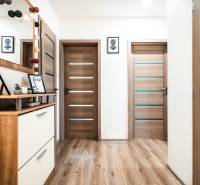 Interior of a 2-room apartment with a wooden decor floor, doors, and decorations.