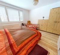 A bedroom in a 2-room apartment with a bed, a wardrobe, and a wooden decor floor.