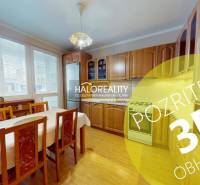 A kitchen in a 2-room apartment with a light wood decor and a dining table.