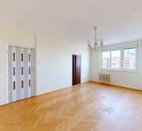 A living room in a 3-room apartment with large windows and a wooden decor floor.