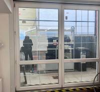 Glass sliding doors in commercial spaces, bicycle, radiator, and plastic film on the wall.