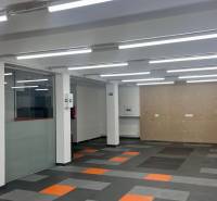 Commercial spaces with carpet flooring and glass partitions.