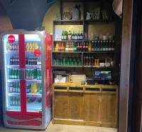Gastro premises with a Coca-Cola refrigerator, shelves with drinks, and a cash register on a floor with a wooden decor.