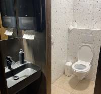 Restroom in dining spaces with a sink, mirror, and terrazzo tiles.