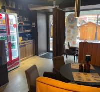 Interior of dining spaces with a round table, chairs, and lighting.