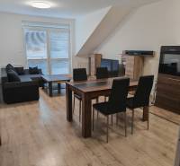 Living room in a 3-room apartment with a wooden decor floor and a dining table.