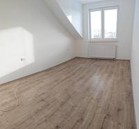 3-room apartment with white walls, wood-patterned flooring, large window, and radiator.