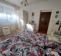 Bedroom in a family house with a bed, wardrobe, and decorative carpet.