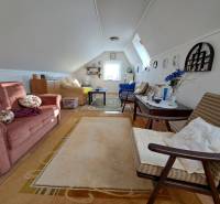 Attic living room in a family house with a sofa bed and decorative accessories.