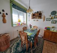 Dining area in a family house with wooden furniture, decorated walls, and carpets.