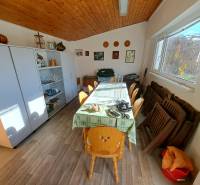 Interior of a family house with a wooden decor floor, dining table, and display cabinet.