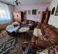 Living room in a family house with a sofa, carpets, decorative furniture, and paintings on the wall.
