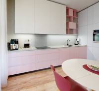 A kitchen unit with pastel cabinets and a wooden decor floor in a 4-room apartment.