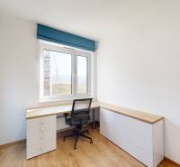 A study with a corner desk, blue cabinets, and a wooden decor floor in a 4-room apartment.