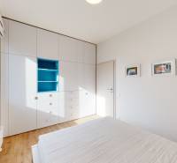 Bright bedroom with a built-in wardrobe and wooden decor flooring in a 4-room apartment.