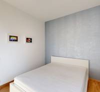 Bedroom with light walls, a bed, and art on the walls, 4-room apartment.