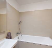 A bathroom with a bathtub and beige tiles in a 4-room apartment.