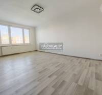 A room with large windows and a wooden decor floor in a 2-room apartment.