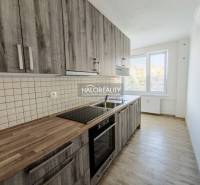 A kitchen in a 2-room apartment with a kitchen unit and a floor with a wooden decor.