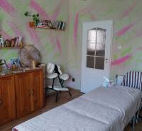 Massage room in a family house with colorful walls and a wooden decor floor.