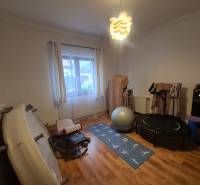 A gym in a family house with exercise equipment and a floor with a wooden design.