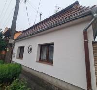 A family house in Komárno with a sloped roof and a landscaped garden.