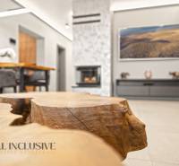 Living room in a family house with a fireplace, decorative wooden table, and comfortable seating.