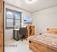 Children's room in a family house with a desk, bed, and wooden decor flooring.