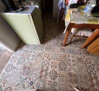 Interior in a family house with colorful tiles and a table with a patterned tablecloth.