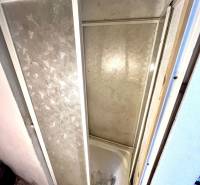 Shower enclosure in the interior of a family house with tiling and decorative flooring.